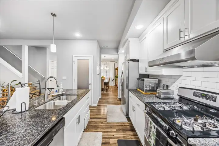 Spacious kitchen with oversized island, pendant lighting, and breakfast bar seating