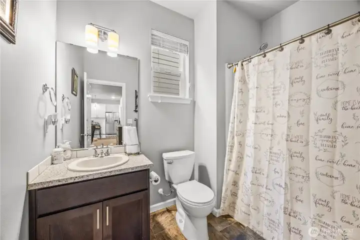 Modern main floor guest bathroom with neutral finishes, full tub/shower combo, and updated fixtures.