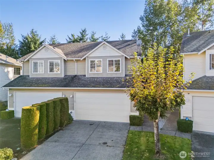 Greeted by a shrub-lined driveway to offer separation and a bit of privacy from the other side of the attached townhouse. 2-car garage plus driveway parking space