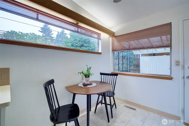 Kitchen nook looks out to a covered patio, the door leads out to it.