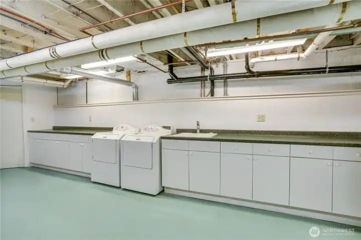Utility room with built-in cabinetry and laundry.