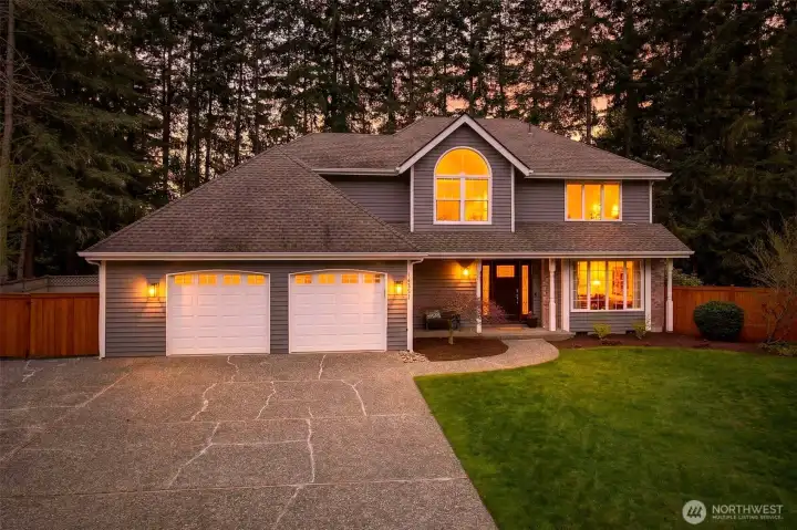 A warm twilight welcome sets the tone — the classic two-story silhouette, arched upper window, and glowing entry make an unforgettable first impression on English Hill.