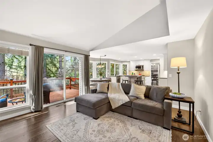 Sliding glass doors in the family room open directly onto the refinished deck, framing a stunning evergreen backdrop — the perfect indoor-outdoor connection for Pacific Northwest living at its best.