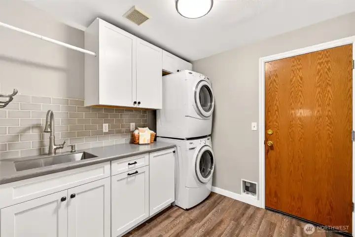 The updated laundry room featuring white shaker cabinetry, subway tile backsplash, utility sink, stacked washer/dryer, and direct garage access for added everyday convenience.    Photo 19 — 14151 174th Pl NE Redmond 19  The main-level powder room makes a bold, stylish statement with rich blue board-and-batten wainscoting, a dark-finish vanity, and warm lighting — a thoughtfully designed space that leaves a lasting impression on guests.    Photo 20 — 14151 174th Pl NE Redmond 20  The generously sized primary bedroom offers a true retreat — with plush carpet, a ceiling fan, and a dramatic navy accent wall that adds a sense of depth and sophistication to this private upstairs sanctuary.    Ready for photos 21–30 when you are.Apr 9Here are descriptions for photos 21–30:    Photo 21 — 14151 174th Pl NE Redmond 21  The spacious primary bedroom offers room to truly unwind — with plush carpet, a ceiling fan, plantation shutters, and a private ensuite just steps