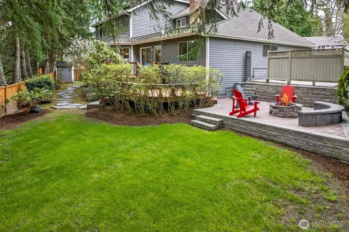 The fully fenced backyard offers a rare combination of space, privacy, and outdoor livability — with a lush lawn, paver patio, fire pit gathering area, and a multi-level deck that elevates outdoor living on English Hill.