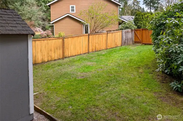 A fully fenced side yard with lawn and mature plantings provides valuable additional outdoor space — ideal for a garden, play area, or simply the extra room and privacy that's increasingly hard to find on the Eastside.
