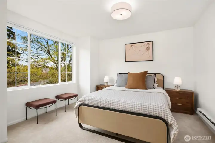 Primary bedroom overlooking mature landscaping, with fresh paint and new carpeting throughout.