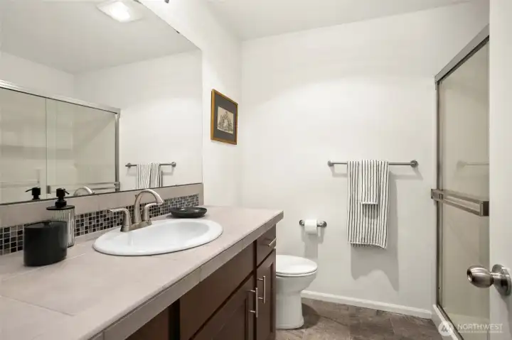 Primary bathroom featuring a walk-in shower, ample counter space, and plenty of storage.