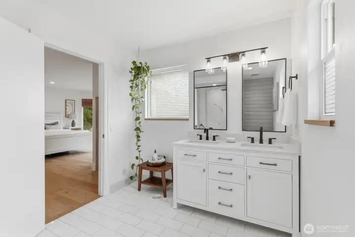 Newly renovated bathroom with Calcutta marble floor, tiled tub/shower with rain shower head, new quartz vanity, portrait mirrors