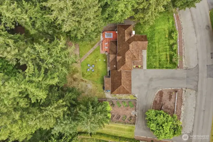 Positioned on a shy level acre in a private park-like setting with mature evergreens backing to a creek.