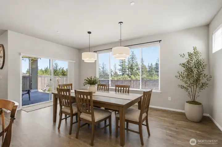 The sliding glass door leads to the covered patio. The dinning area easily holds a large table and still leaves room for furniture and accessories. The table set is virtual staging but the designer lighting is included. The sliding glass door leads to the covered patio. The dinning area easily holds a large table and still leaves room for furniture and accessories. The table set is virtual staging but the designer lighting is included.