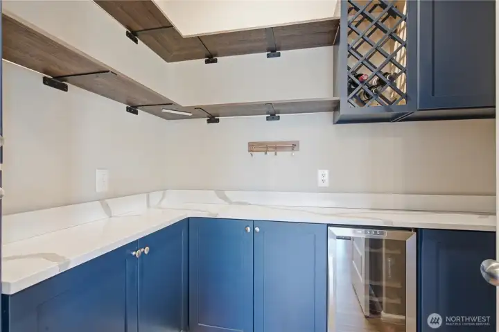 The walk-in pantry compliments the kitchen with matching cabinetry and counters. Wine rack and beverage fridge. The walk-in pantry compliments the kitchen with matching cabinetry and counters. Wine rack and beverage fridge.