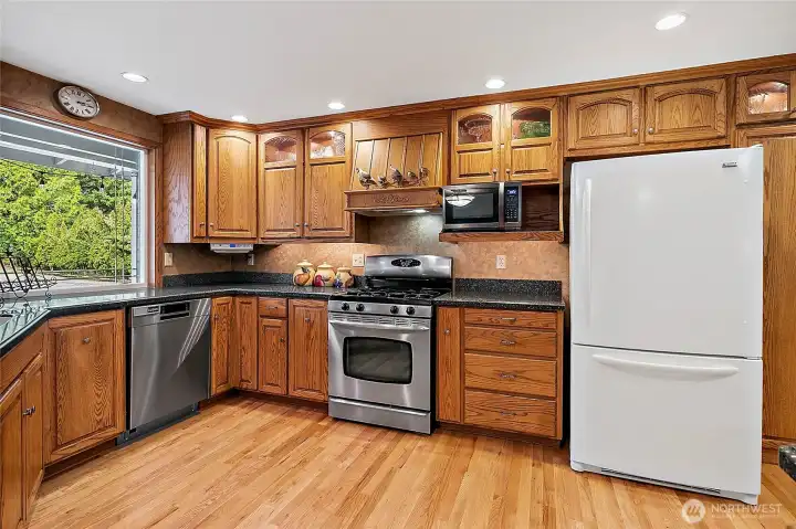 Custom Cabinets and Corian Counter Tops! Lovely Beveled window overlooks front of property and lush landscaping.
