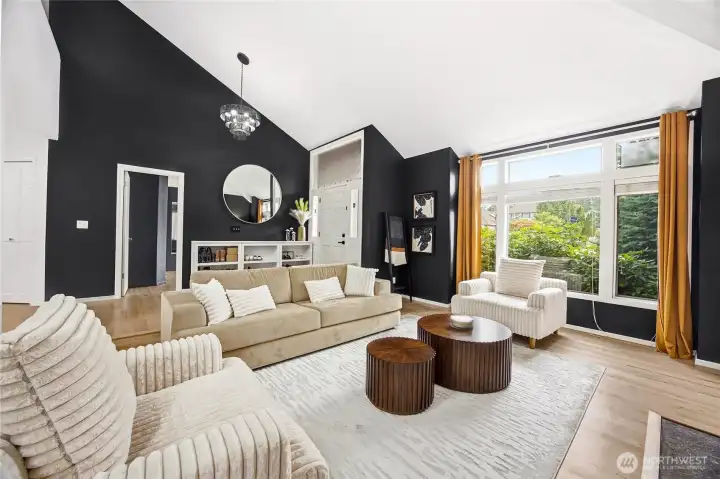 Another stunning angle of the living room showcasing the extensive window lines and modern designer lighting fixtures that elevate this bright, open floor plan.