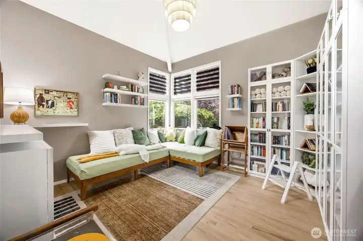 Bright and versatile secondary main-level dining room or den, lined with gorgeous  floor-to-ceiling built-in bookcases and storage cabinetry.