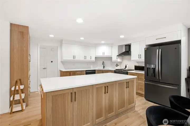 Looking out from the kitchen across the sprawling island into the main living areas, demonstrating an ideal open layout for hosting and entertaining guests.