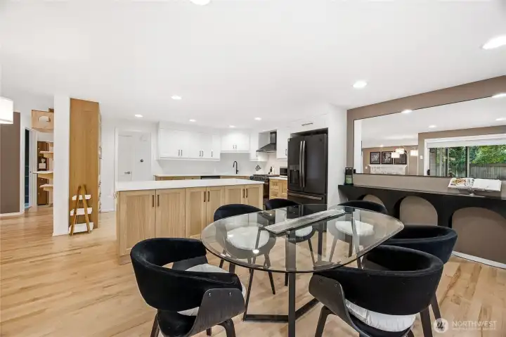 Bright and airy overview of the kitchen and casual dining footprint, highlighting the modern recessed lighting, clean lines, and pristine hard-surface flooring.