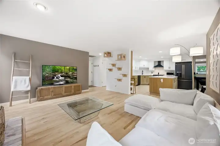 View looking across the family room, showcasing the modern designer paint tones, immaculate baseboards, and expansive window lines that look out toward the private backyard greenery.