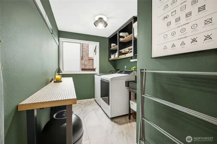 Dedicated main-floor utility mudroom and laundry center, masterfully updated with custom deep hunter-green designer cabinetry, a butcher-block style workspace, and extensive built-in storage.