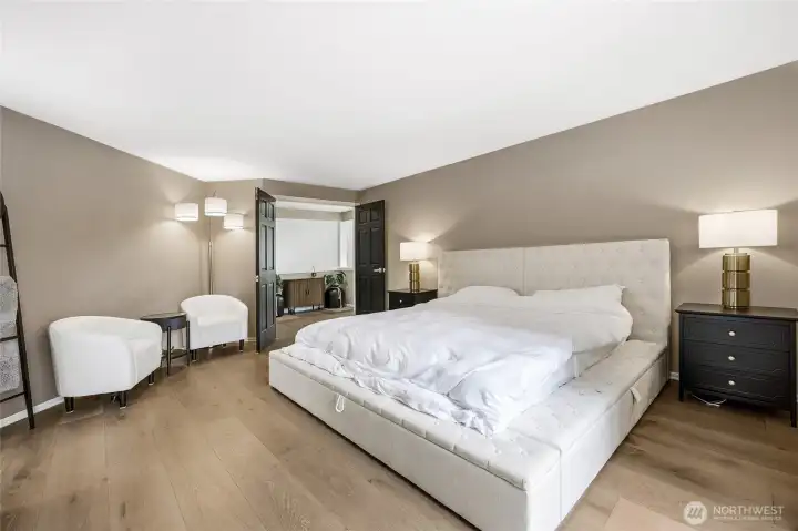 Sprawling primary suite retreat boasting generous square footage, bright natural light, crisp modern trim lines, and a peaceful neutral color palette.