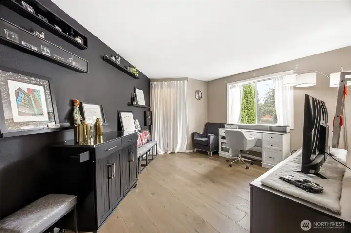 Fourth versatile bedroom or dedicated home workspace on the main level, showcasing soft neutral tones, pristine modern baseboards, and endless layout possibilities to fit your lifestyl