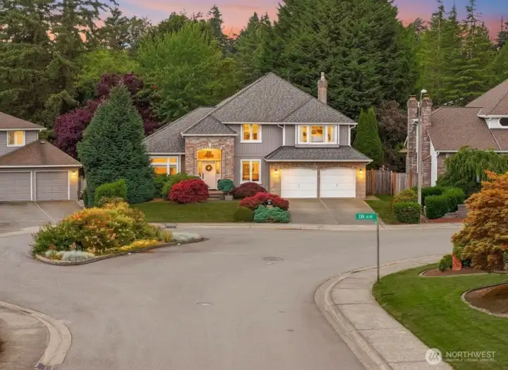 Twilight exterior view highlighting the property’s warm interior glow, architectural landscape potential, and commanding evening curb appeal.