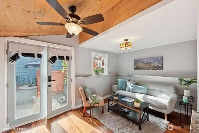 Casita living room with ceiling fan and door to patio and pool.