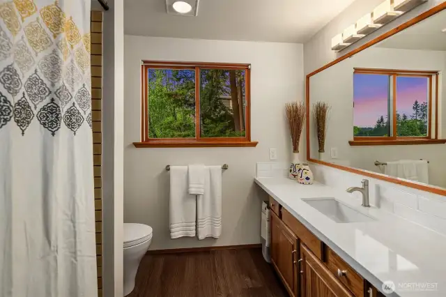 The upstairs main bath has new quartz countertops and tile backsplash.