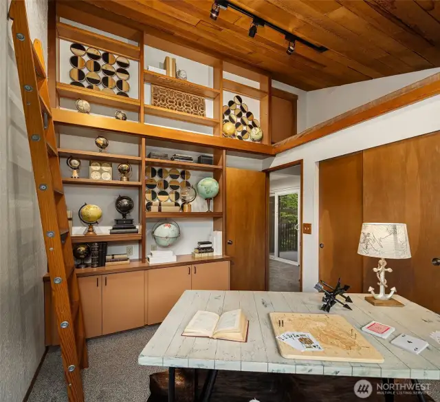 Note the loft bed above and rows of shelves!