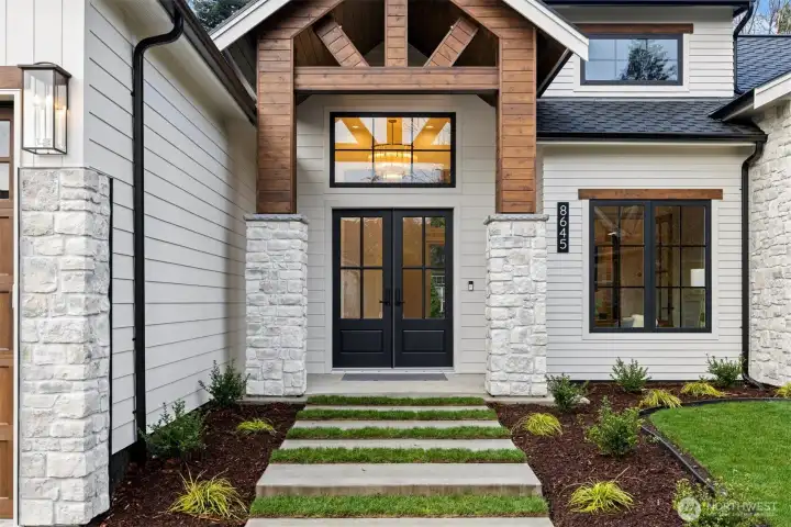 Smooth Hardie siding, Casa Blanca stone, cedar accents and black-framed casement windows create a refined exterior presence.