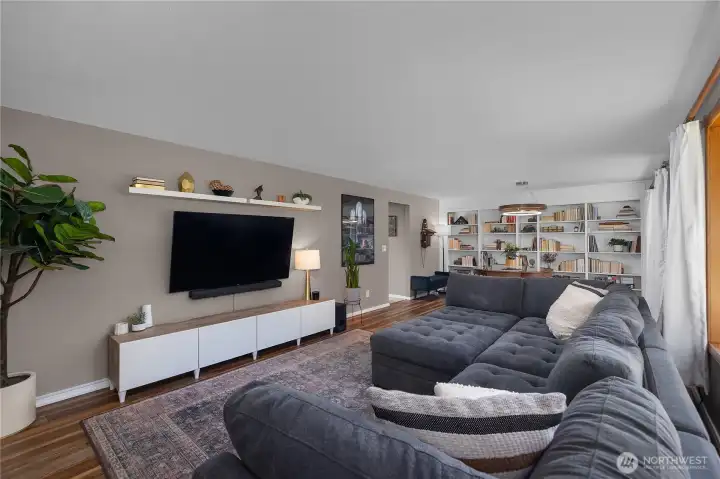 Living room with tons of space and an abundance of natural light. Dining space towards rear with beautiful built ins.