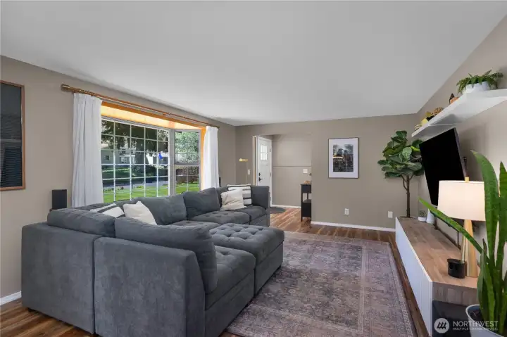 Alternate view of living room from dining space facing front door to the left.