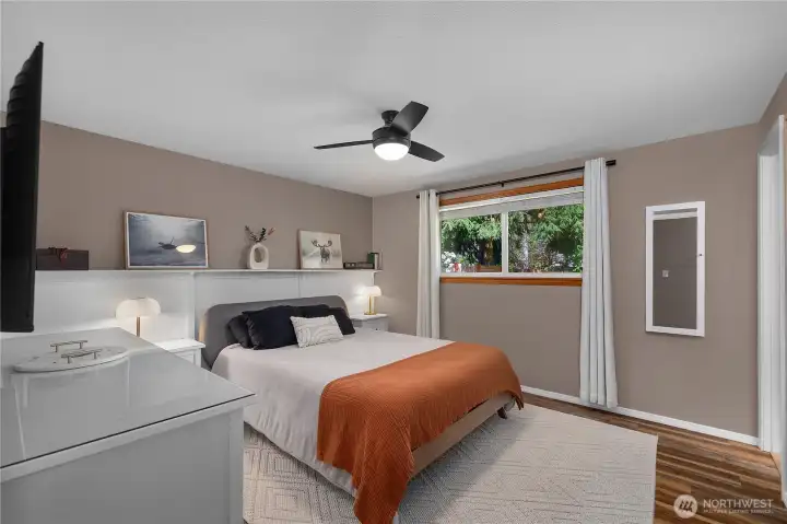 Fantastic sized primary suite! Wainscoting and built in shelf give space a custom feel. En suite bath lies directly to the right.