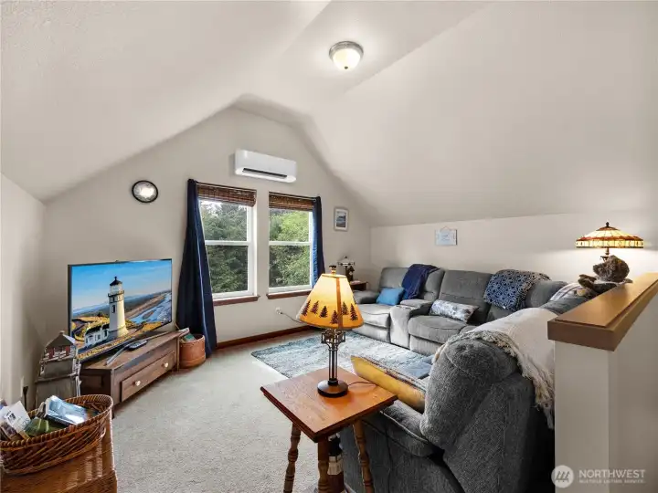 Bright and versatile living area with vaulted ceilings and cozy gathering space.