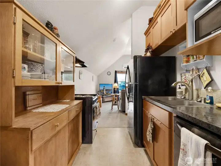 Galley-style kitchen with abundant cabinetry and open sightlines through the loft.