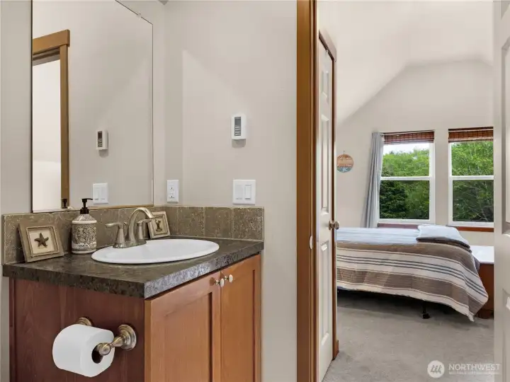 Bathroom vanity area conveniently located adjacent to the bedroom space.