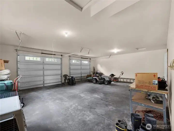 Oversized garage with high ceilings and ample room for vehicles, storage, hobbies, or workshop use.