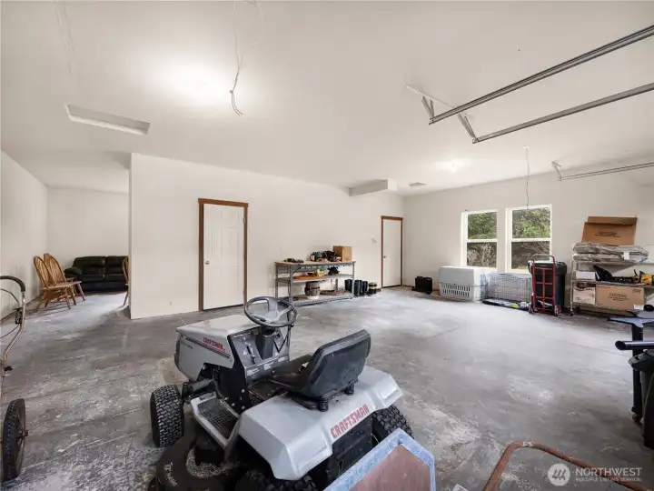 Large multi-use garage area with room for vehicles, tools, and recreational gear.