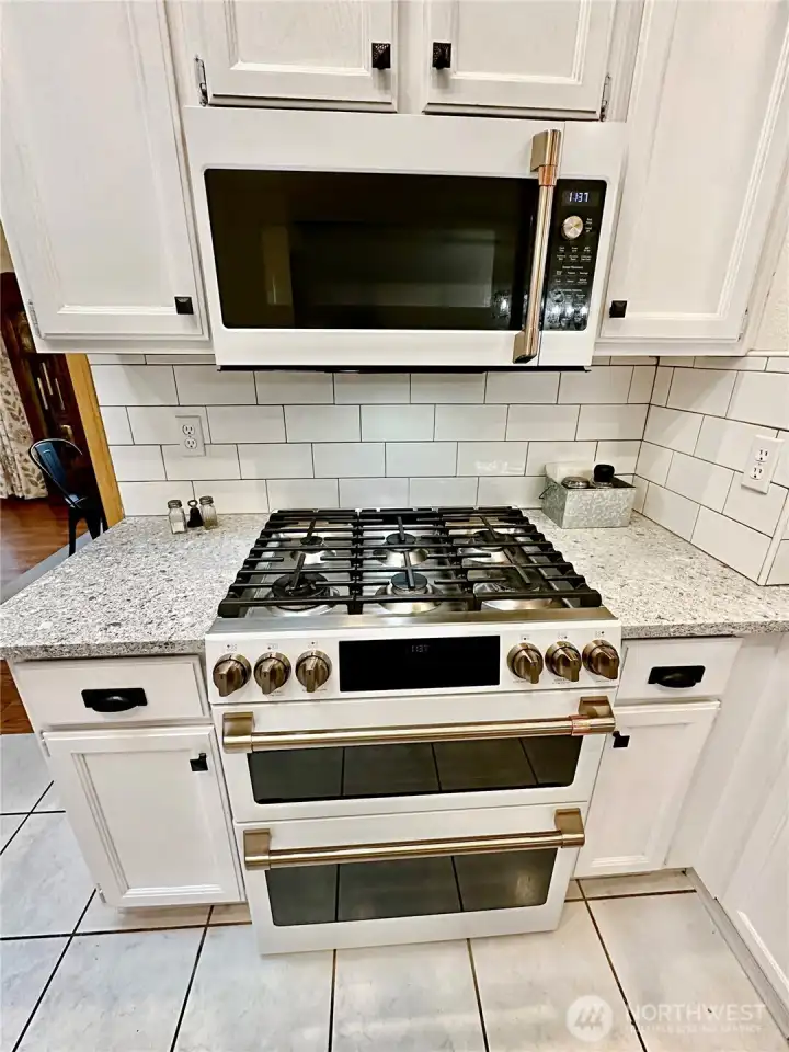 Close up view of the gas cook-top range with double ovens and microwave above. Close up view of the gas cook-top range with double ovens and microwave above.