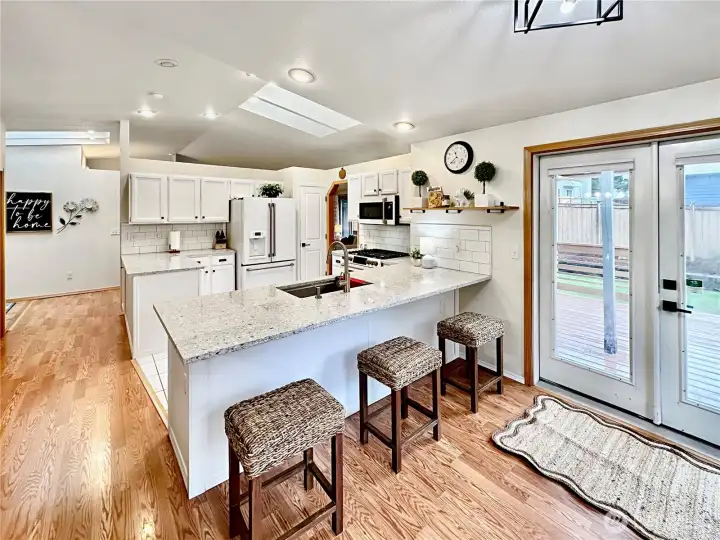 The kitchen offers a nice size eating bar and double doors to the rear deck with covered BBQ area and fenced backyard. The kitchen offers a nice size eating bar and double doors to the rear deck with covered BBQ area and fenced backyard.