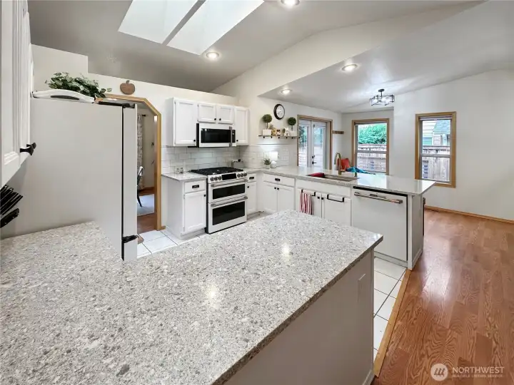 Looking through the kitchen to the window seat and French doors leading to the rear deck and backyard. Looking through the kitchen to the window seat and French doors leading to the rear deck and backyard.
