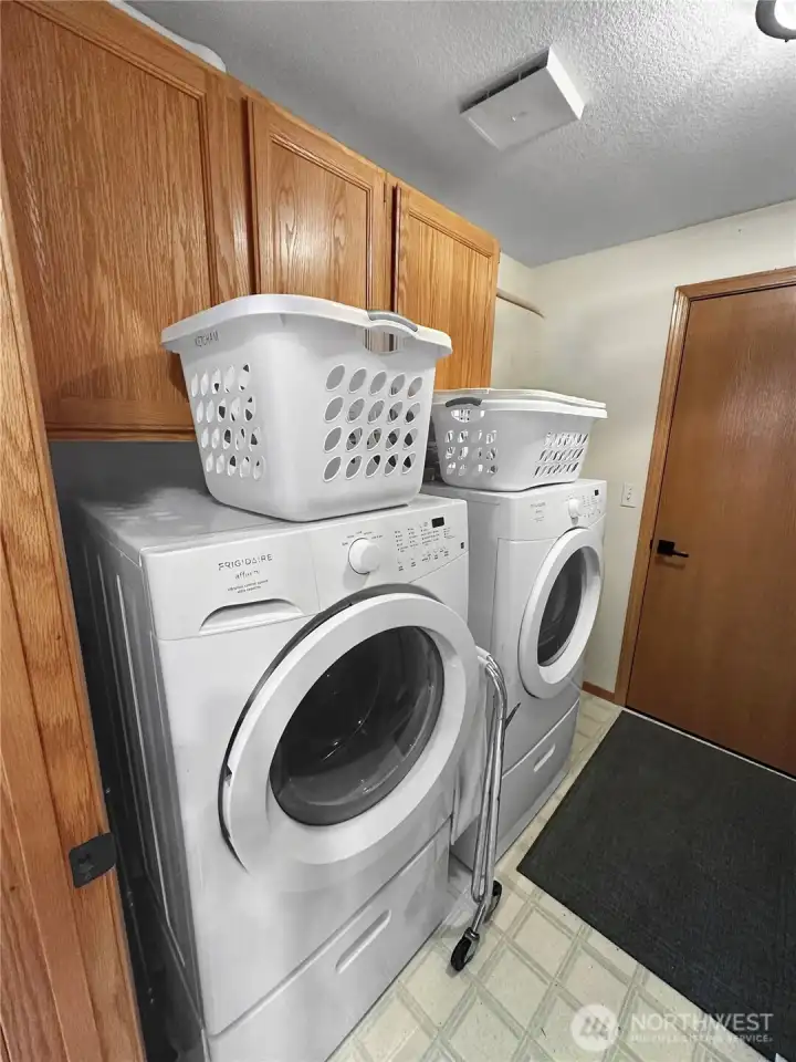 Laundry room with storage cabinets and washer/dryer. Laundry room with storage cabinets and washer/dryer.