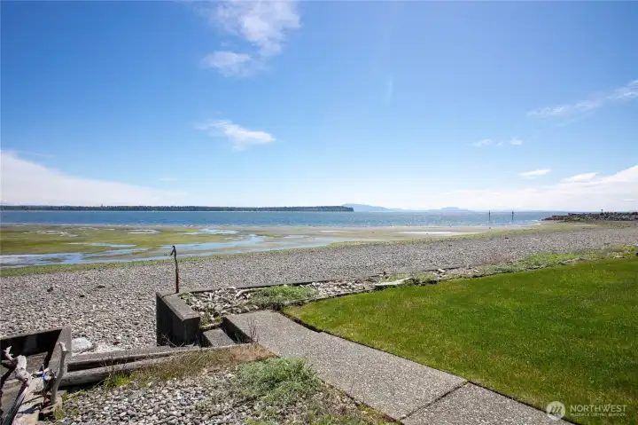 Looking South with steps down to the beach and concrete bulkhead. San Juan Islands in the far distance Looking South with steps down to the beach and concrete bulkhead. San Juan Islands in the far distance