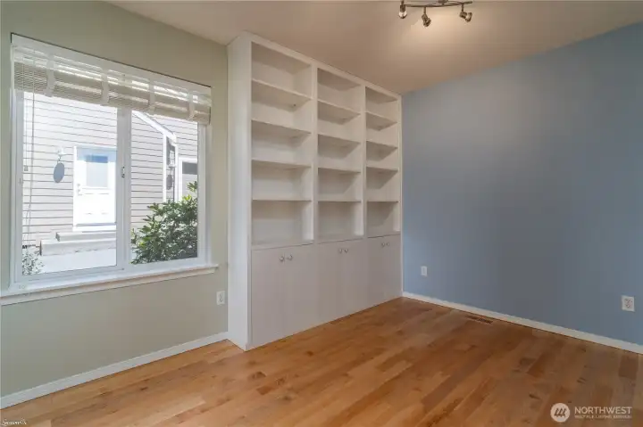 Main floor bedroom with Build ins, newly finished hardwood floors.