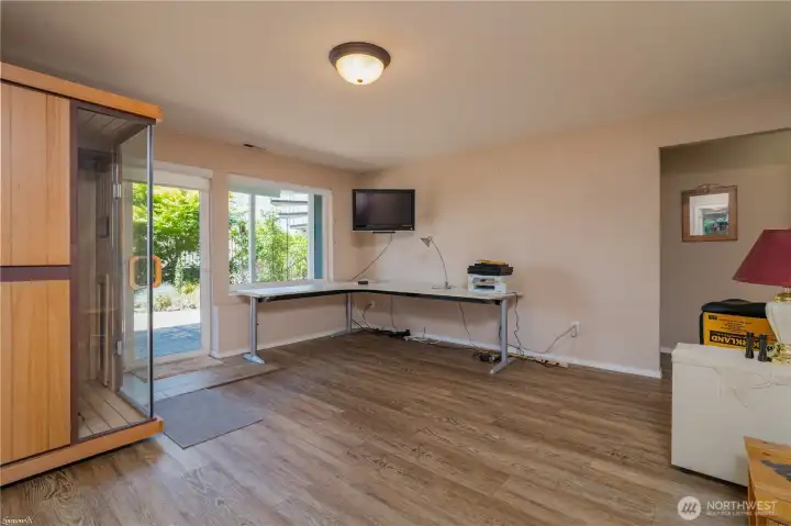 Spacious downstairs living room featuring large windows and an open floor plan.