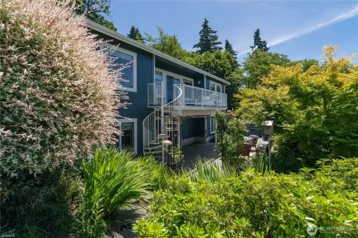 Steps leading down from the upper patio to the rear patio.  Lovely landscaping and walk way to the front of the home.