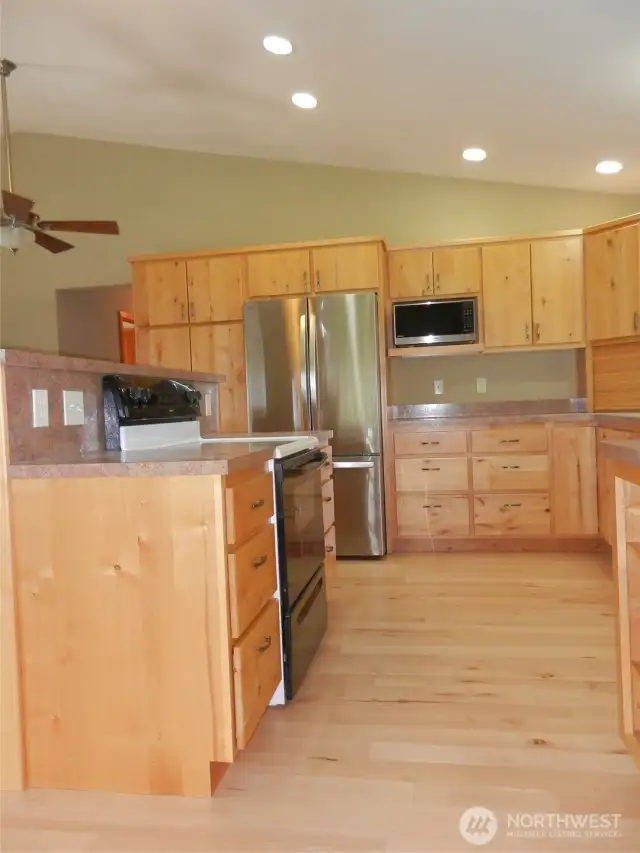 Kitchen with new refrigerator and microwave.
