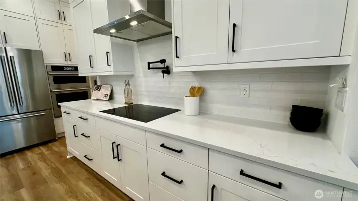 Chef's dream kitchen including induction cooktop and Jenn Air Rise appliances (staging and furniture are for decoration and not included in the sale of this home)