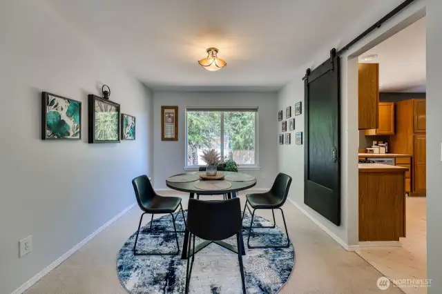 The formal dining room flows nicely into the kitchen. The sliding barn door is a classy touch.