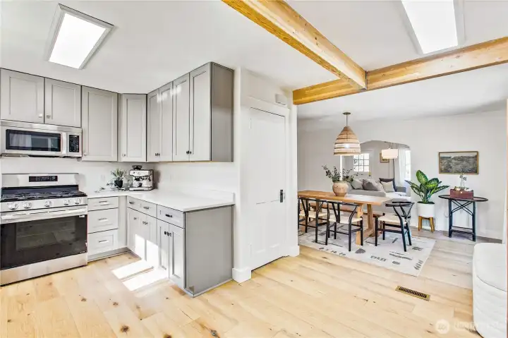 Fully remodeled bright, modern kitchen with Thomasville soft-close shaker cabinetry, updated cabinet hardware, Carrara quartz countertops, LG stainless appliances with dual ice maker, and warm wood accents.